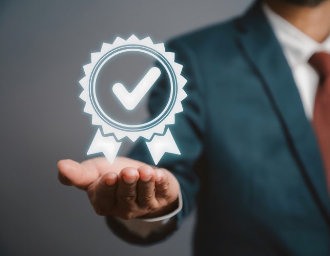 vecteezy_businessman-holding-quality-assurance-and-iso-certification_57838294